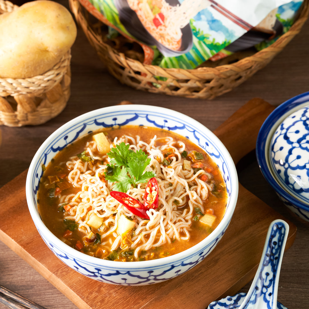 Massaman curry ramen prepared in a bowl with fresh chili and coriander