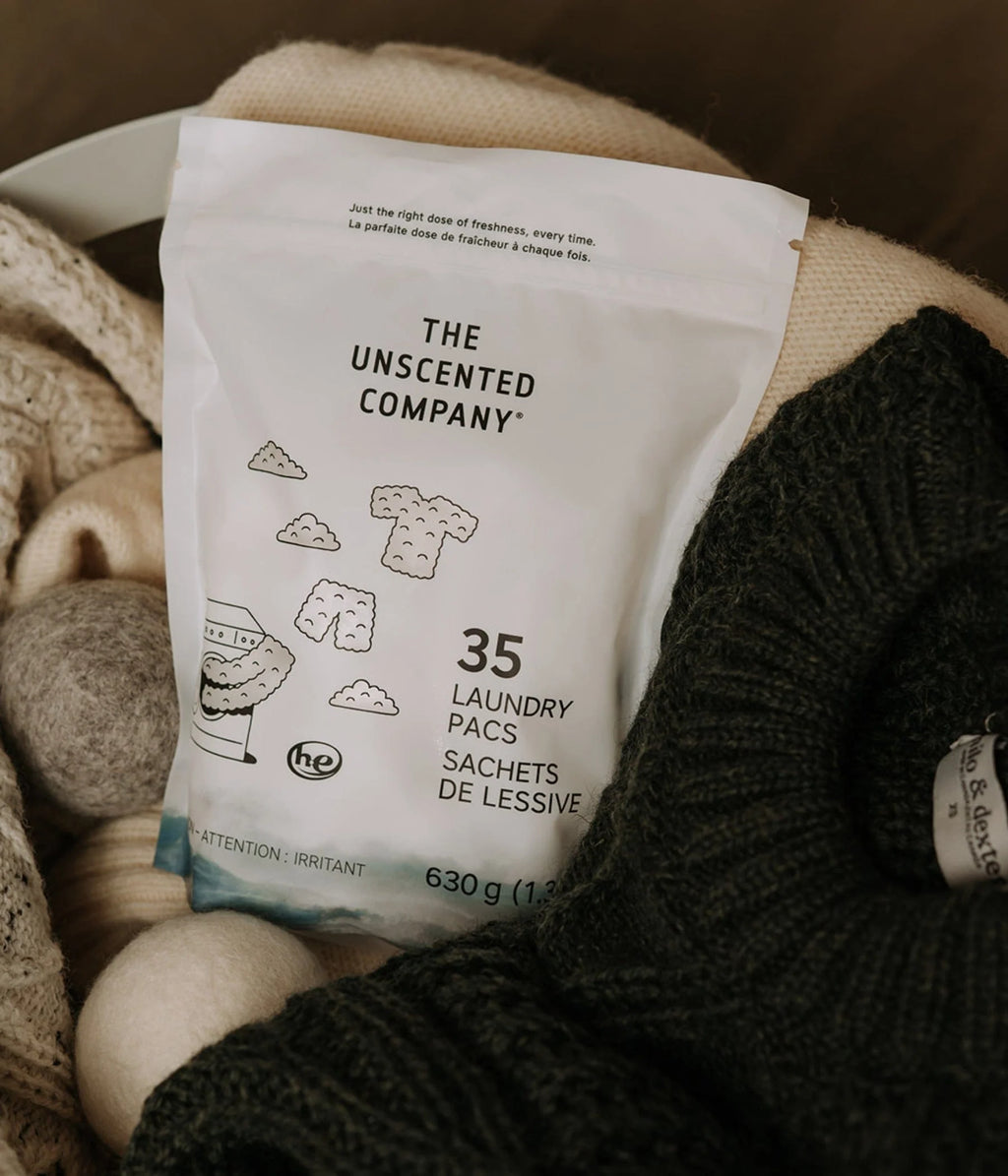 The laundry pac pouch resting in a basket of folded knitwear