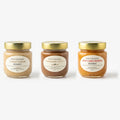 Three 250 g jars of Eat Raw Honey raw creamed honey side by side: lemon ginger, cinnamon and hot chili pepper