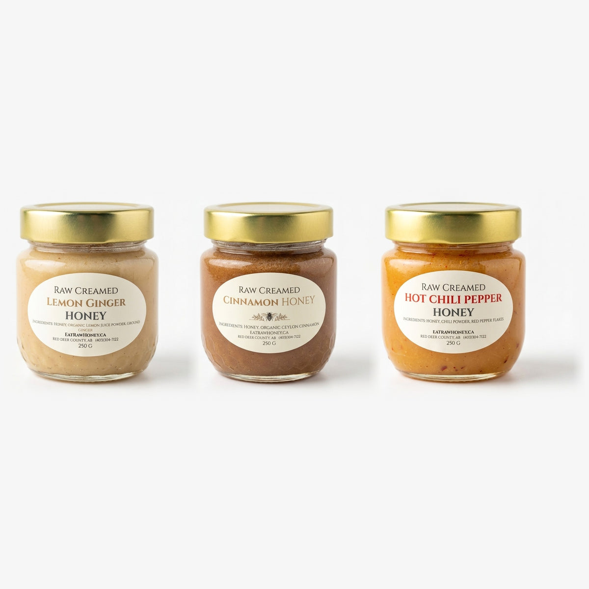 Three 250 g jars of Eat Raw Honey raw creamed honey side by side: lemon ginger, cinnamon and hot chili pepper