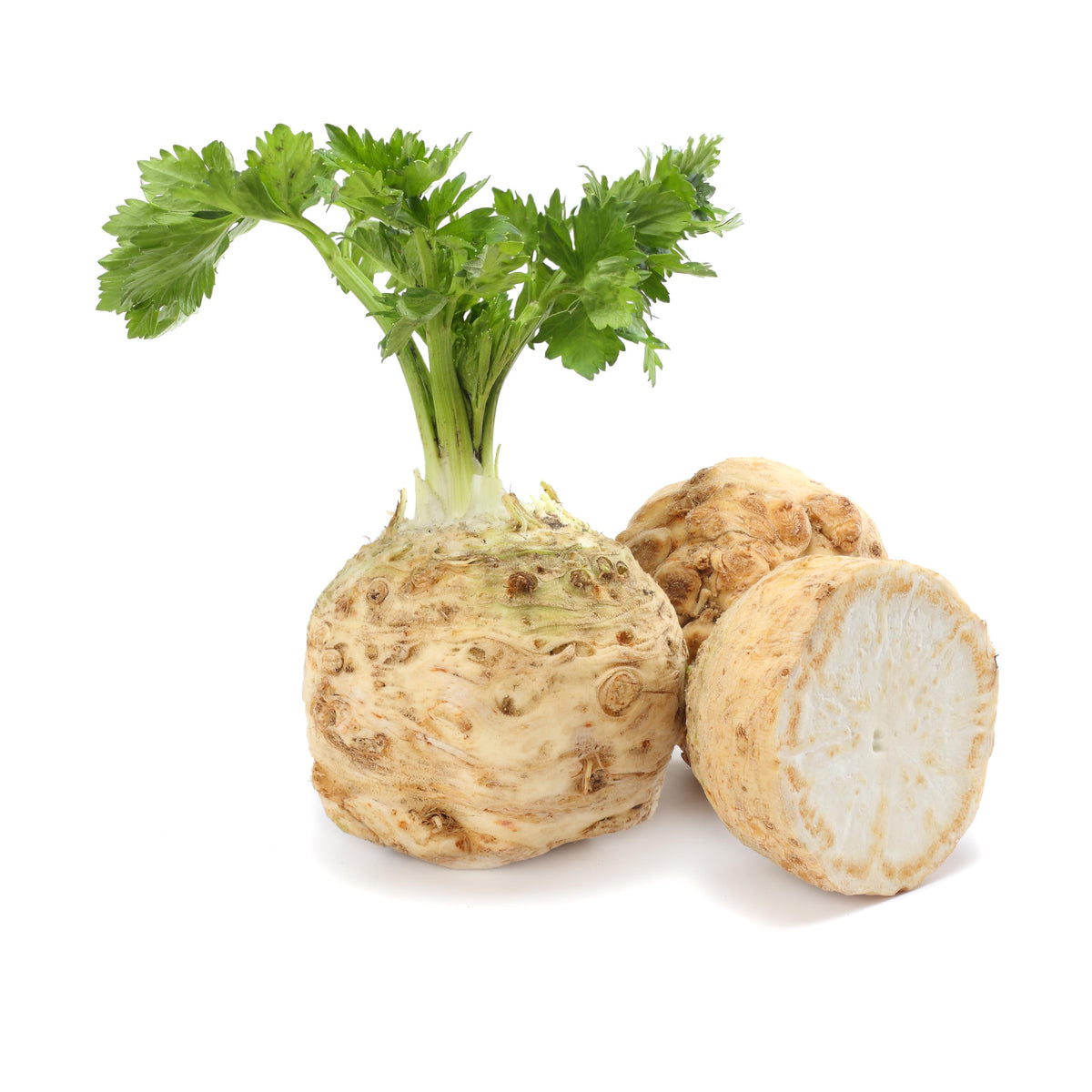 Whole celeriac root with celery leaves on top, beside a second root and a half cut to show the white inside